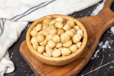 Macadamia fındığı. Tahta kasede Macadamia fındığı. Süper yemek. Vejetaryen gıda konsepti. Sağlıklı atıştırmalıklar. Kapat.
