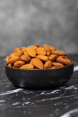Badem. Kâsede organik badem fıstığı var. Süper yiyecek, vejetaryen gıda konsepti. Sağlıklı atıştırmalıklar. Kapat şunu.