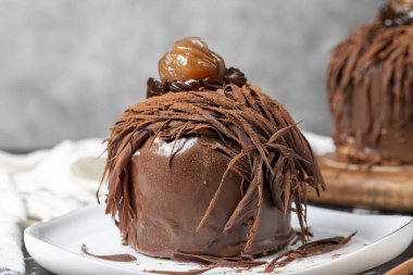 Kestane keki. Koyu arkaplanda çikolata, krema ve kestane rengi pasta. Kapat.