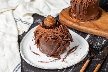 Kestane keki. Koyu arkaplanda çikolata, krema ve kestane rengi pasta