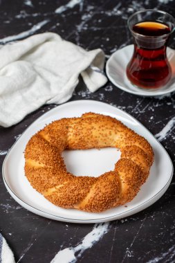 Siyah arka planda susamlı simit. Türk sokak yemekleri dairesel ekmek, susamlı simit. Simit ya da gevrek. 