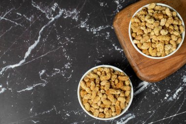 Kurutulmuş dut. Seramik kasede güneşte kurutulmuş dut. Süper yemek. Vejetaryen gıda konsepti. Sağlıklı atıştırmalıklar. Üst Manzara. Uzayı kopyala Metin için boş boşluk