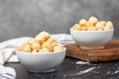 Macadamia fındığı. Seramik kasede soyulmuş Macadamia fındığı. Süper yemek. Vejetaryen gıda konsepti. Sağlıklı atıştırmalıklar. Kapat.