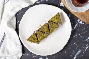 Fıstıklı ve çikolatalı kurabiye. Koyu arka planda lezzetli kurabiyeler. Üst görünüm