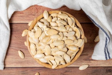 Balkabağı çekirdeği. Tahta kasede güneşte kurutulmuş kabak çekirdeği. vejetaryen yemek konsepti. Sağlıklı atıştırmalıklar. Üst görünüm