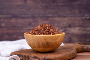 Ahşap arka planda keten tohumu. Tahta kasede keten tohumu veya keten tohumu