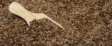 Keten tohumları arka plan veya doku. Keten tohumu ya da tahta kaşıkta keten tohumu. Mısır gevrekleri sağlıklı. Uzayı kopyala Metin için boş boşluk