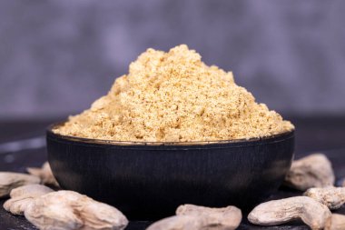 Koyu arkaplanda zencefil tozu. Kavanozda kurutulmuş zencefil