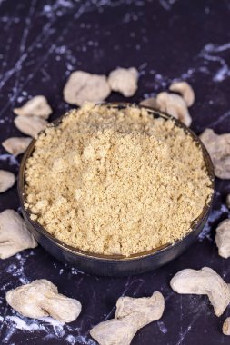 Koyu arkaplanda zencefil tozu. Kavanozda kurutulmuş zencefil