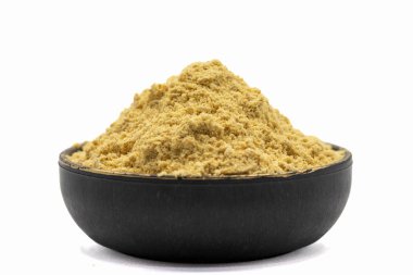 Zencefil tozu beyaz arkaplanda izole edilmiş. Kasede zencefil tozu