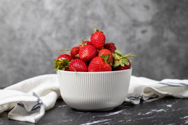Kasede çilek. Organik tarım ürünleri. Koyu arkaplanda taze çilekler.