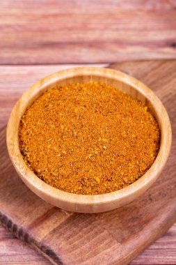 Ahşap arka planda Cajun baharat tozu. Ahşap kasede kurutulmuş Cajun.