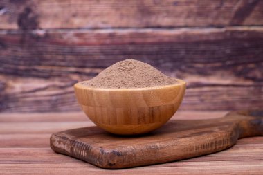 Ahşap arka planda baharat tozu. Ahşap kasede kurutulmuş tüm baharatlar. Pimento baharat, Jamaika biberi ve talaş.