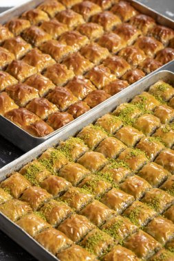 Türk baklavası. Fıstıklı ve cevizli baklava koyu bir arka planda. Türk mutfağı lezzetleri. Kapat.