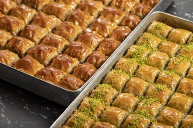 Türk baklavası. Fıstıklı ve cevizli baklava koyu bir arka planda. Türk mutfağı lezzetleri