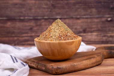 Karışık baharat. Nane, çemen unu, karabiber, poyotu, kekik, sumac, kişniş tozu, ahşap zemin üzerinde kırmızı biber karışımı ile hazırlanmış baharatlar. Ahşap kasede karışık baharatlar.