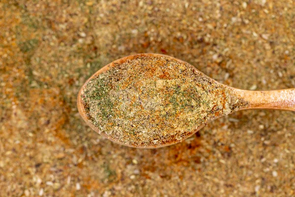 Mixed spices on wooden spoon. Powdered mixed spice close up. Top view