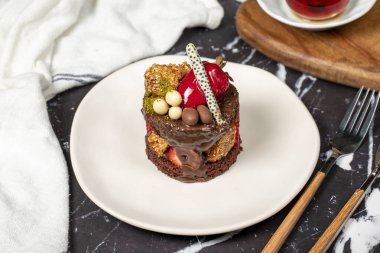 Çikolata, Çilek ve Fıstıklı Kek. Koyu arkaplanda lezzetli bir pasta.