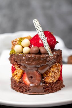 Çikolata, Çilek ve Fıstıklı Kek. Koyu arkaplanda nefis bir pasta. Kapat.