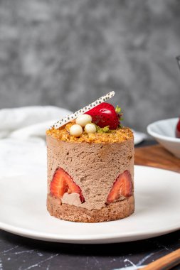 Çilek, Croquant ve Pistachio Pastası. Koyu arkaplanda nefis kremalı pasta. Kapat.