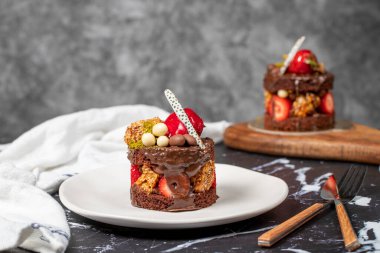 Çikolata, Çilek ve Fıstıklı Kek. Koyu arkaplanda lezzetli bir pasta.