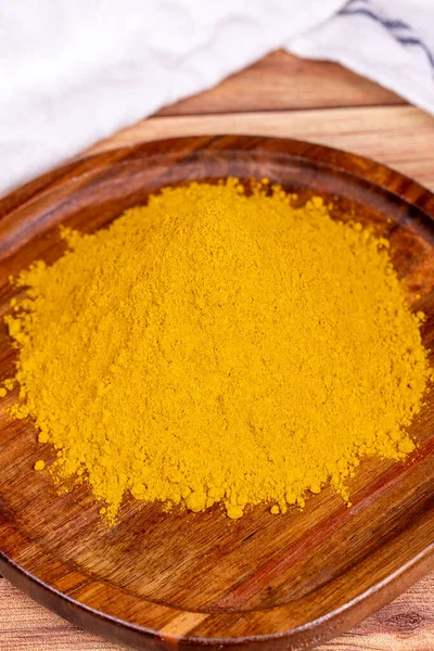 Curry powder on wooden background. Curry powder in wooden bowl. Mixture of spices and dried herbs. Spice concept