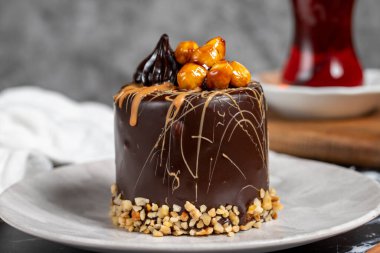 Koyu mermer masada karamel ve çikolatalı pasta. Tabakta lezzetli bir pasta