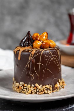 Koyu mermer masada karamel ve çikolatalı pasta. Tabakta lezzetli bir pasta
