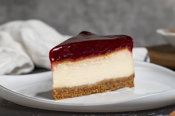 Cheesecake with raspberry flavor on a dark background. a piece of cheesecake on a white plate