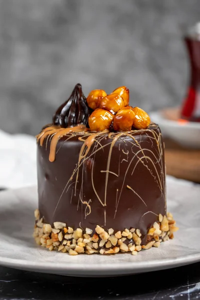Koyu mermer masada karamel ve çikolatalı pasta. Tabakta lezzetli bir pasta