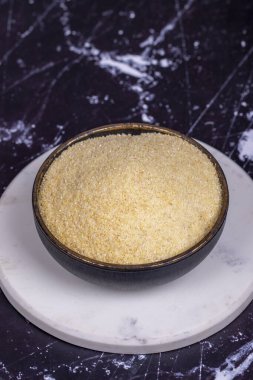 Koyu arkaplanda kurumuş organik irmik kokulu un. Kasede pişmemiş organik irmik.