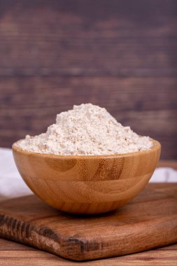 Ahşap arka planda Mahlep tozu. Tahta kasede Mahlep tozu. Kapat.