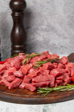 Küplere kesilmiş çiğ et. Tahta bir servis tahtasında doğranmış et ya da kuzu eti