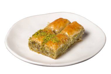 Beyaz arka planda şam fıstıklı baklava. Geleneksel Türk baklavası tabakta. Stüdyo çekimi. Kapat.