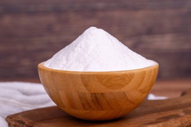 Ahşap zemin üzerinde sodyum bikarbonat ya da kabartma tozu. Ahşap kasede sodyum bikarbonat tozu. Kapat.