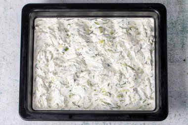 Gri arka planda Tzatziki ya da kakik. Kurutulmuş nane, tuz, zeytinyağı ve yoğurt ile hazırlanmış bir aperatif. sağlıklı aperatifler. Yerel adı kuru cacik