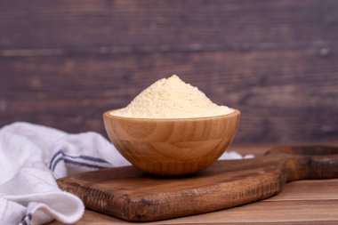 Ahşap arka planda mısır unu. Tahta kasede mısır unu. Kapat.