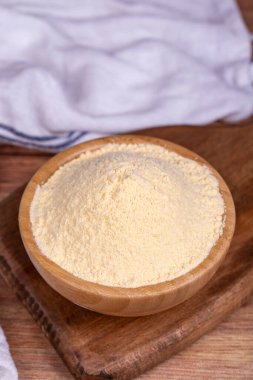 Ahşap arka planda mısır unu. Tahta kasede mısır unu. Kapat.