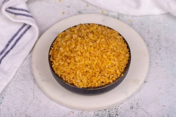 Taş zeminde Bulgur. Bulgur buğday taneleri kasede