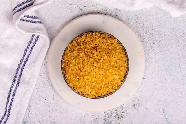Taş zeminde Bulgur. Kasede bulgur buğday taneleri. Üst görünüm