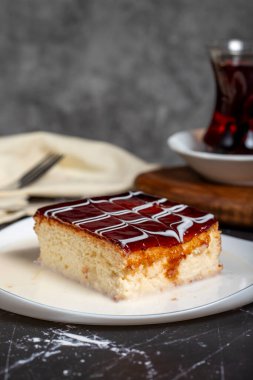 Süt ve karamel ile üç kat tatlı. Koyu arkaplanda karamel keki dilimi. Kapat.