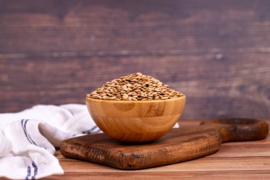 Ahşap arka planda yeşil mercimek. Tahta kasede çiğ yeşil mercimek