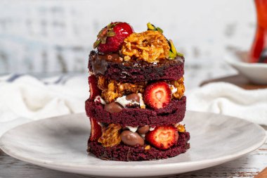 Katmanlı kek. Çilek, şam fıstığı, timsah ve ahşap kaplama kremalı pasta. Kapat.