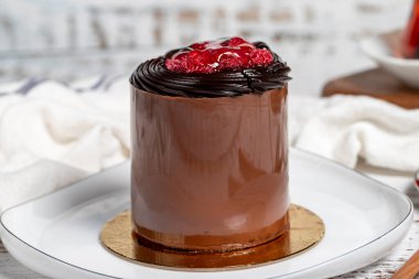 Çikolatalı pasta. Ahşap arka planda ahududu, çikolata ve kremalı pasta. Kapat.