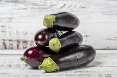 Eggplant on a white wood background. Fresh raw eggplant harvest season concept. Vegetables for a healthy diet. Close up