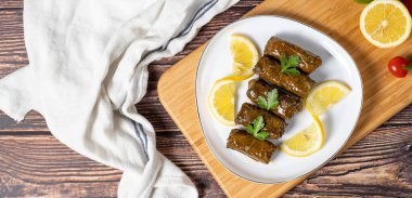 Zeytin yağı yaprağı sarması. Türk mutfağı lezzetleri. Ahşap arka planda üzüm yaprakları sarmak. Yerel adı Zeytinyagli yaprak sarma veya dolma. Üst Manzara. Uzayı kopyala Metin için boş boşluk