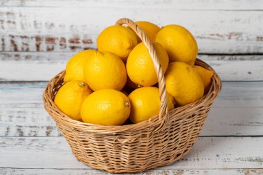 Tahta arka planda sepetin içinde taze limon. Limon hasat mevsimi. Sağlıklı bir diyet için sebzeler