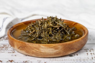 Tahta kasede zeytinyağlı siyah kekik. Beyaz ahşap arka planda Zahter. Akdeniz yemekleri. vejetaryen yemeği