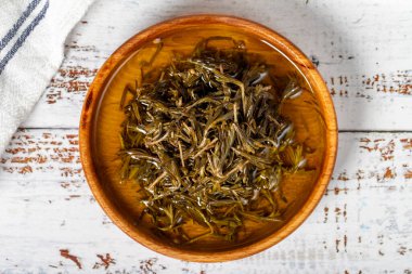 Tahta kasede zeytinyağlı siyah kekik. Beyaz ahşap arka planda Zahter. Akdeniz yemekleri. Vejetaryen yemeği. Üst görünüm