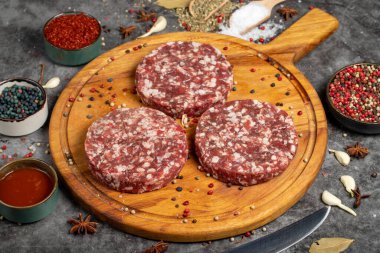 Sığır burger köftesi. Koyu arka planda taze çiğ biftek köftesi. Kasap ürünleri